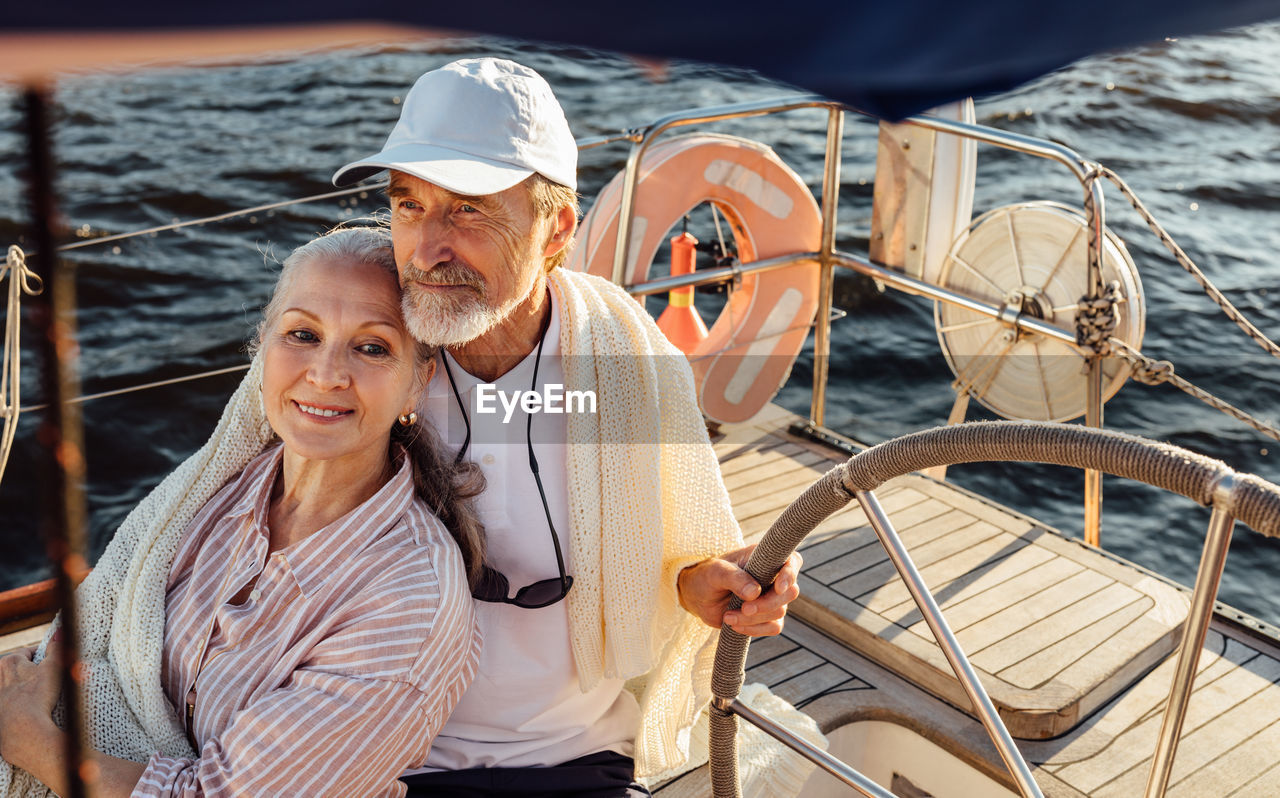 Senior couple embracing while sitting in boat at sea