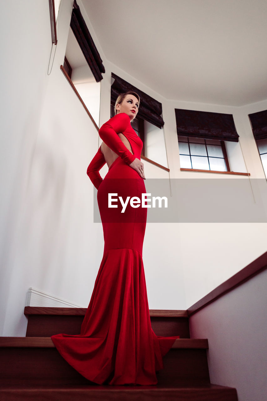 Low angle view of woman red wearing gown on steps