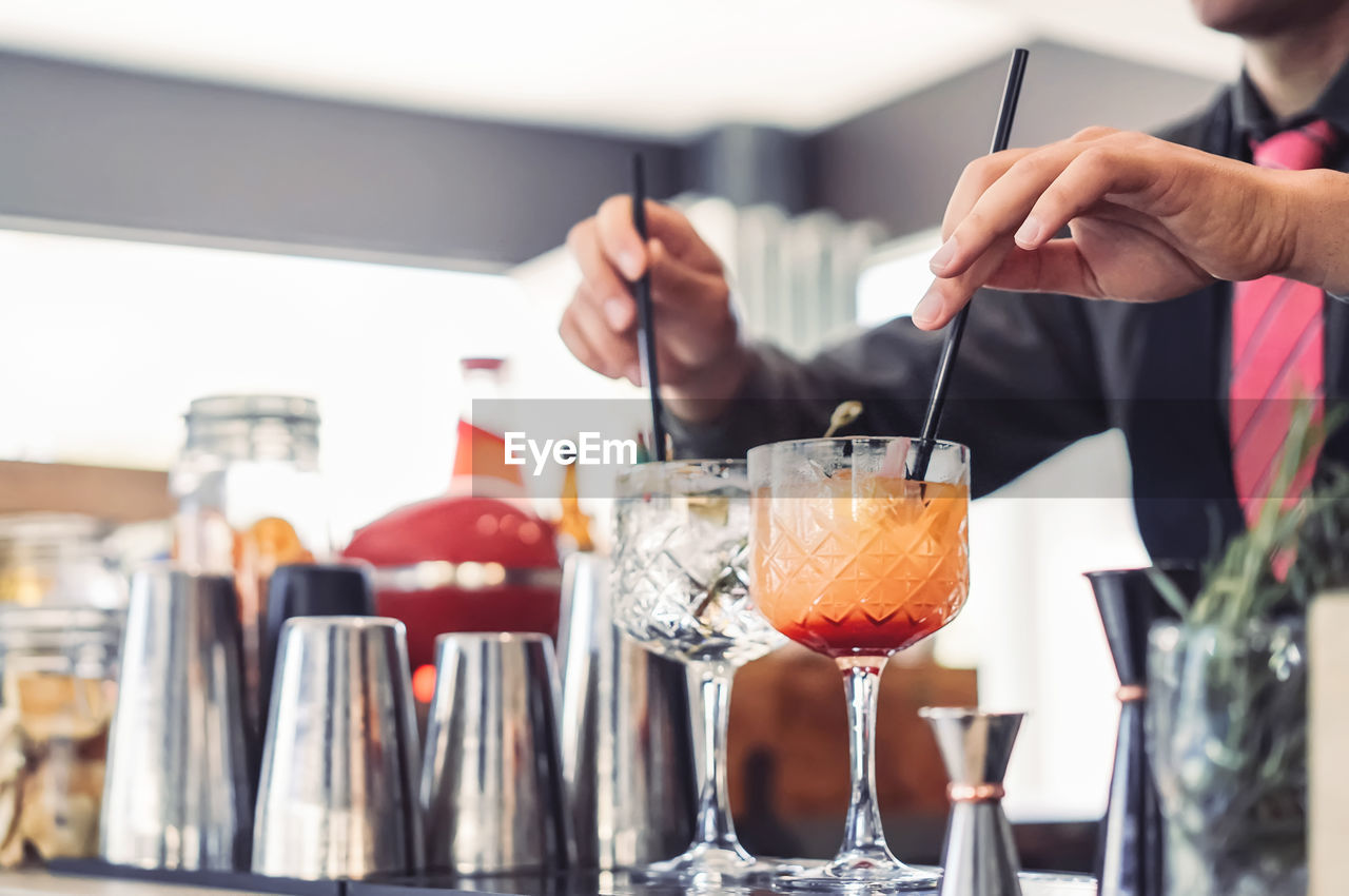 Midsection of man preparing cocktail at pub