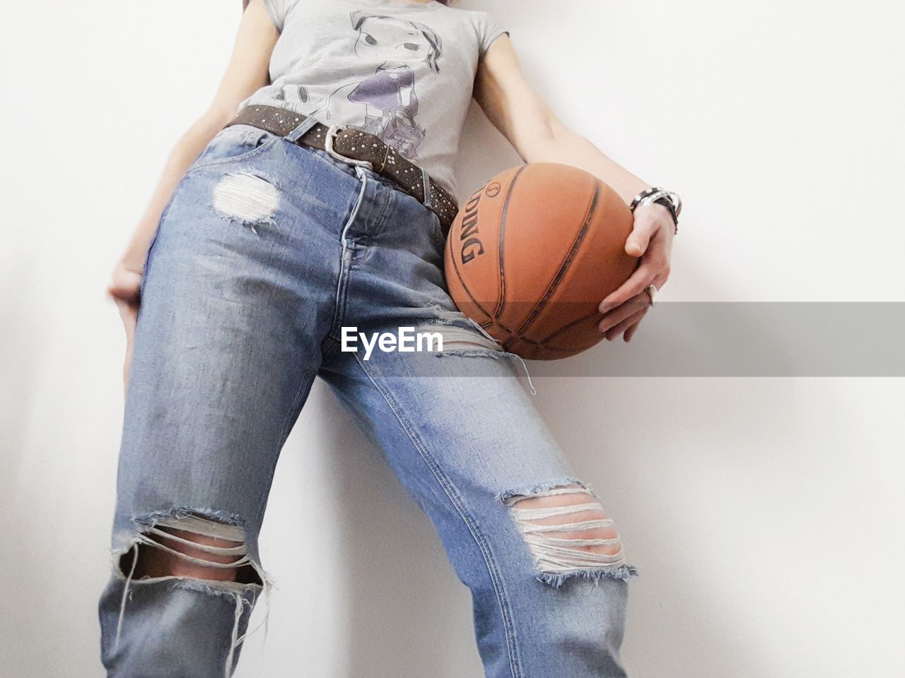 Midsection of woman with basketball against white background