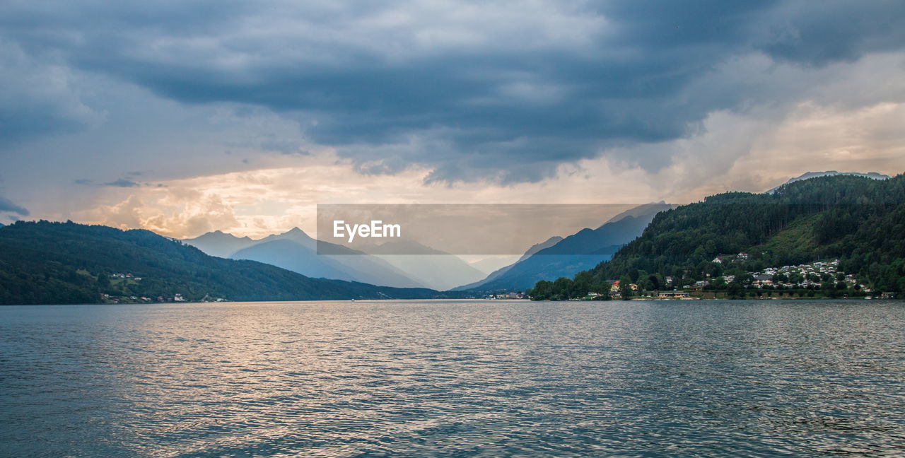 Scenic view of lake by mountains against sky
