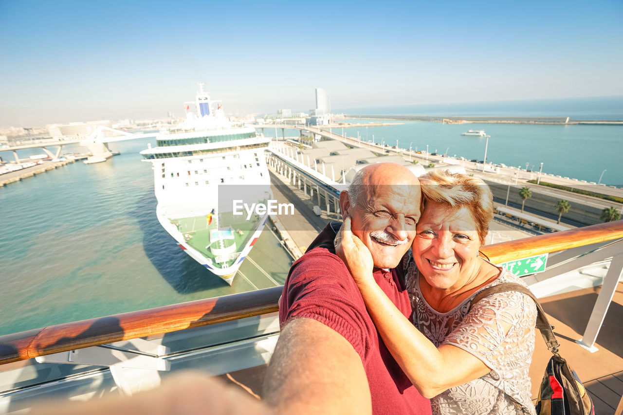 Portrait of senior couple on boat against sky