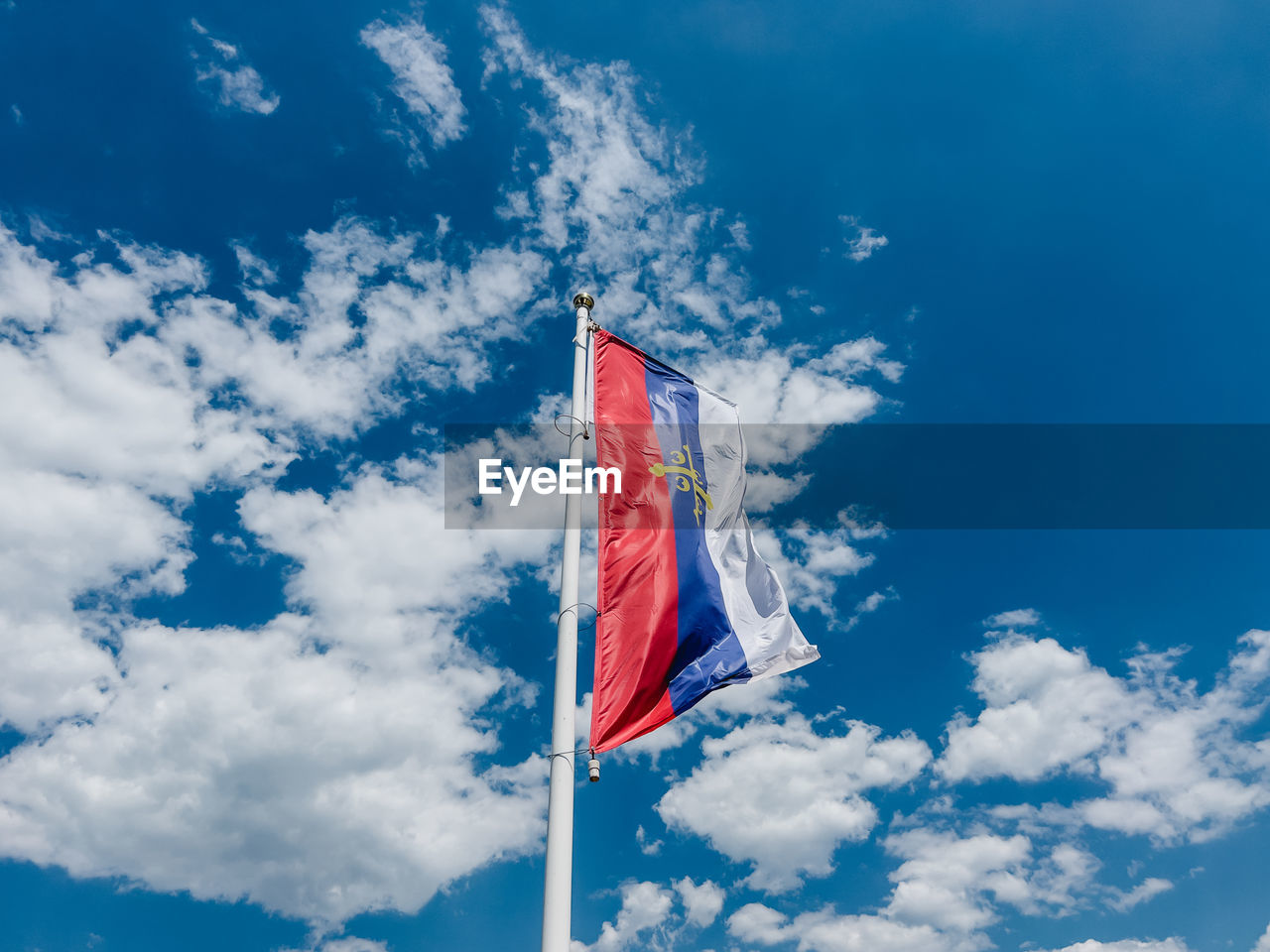 low angle view of flag against cloudy sky