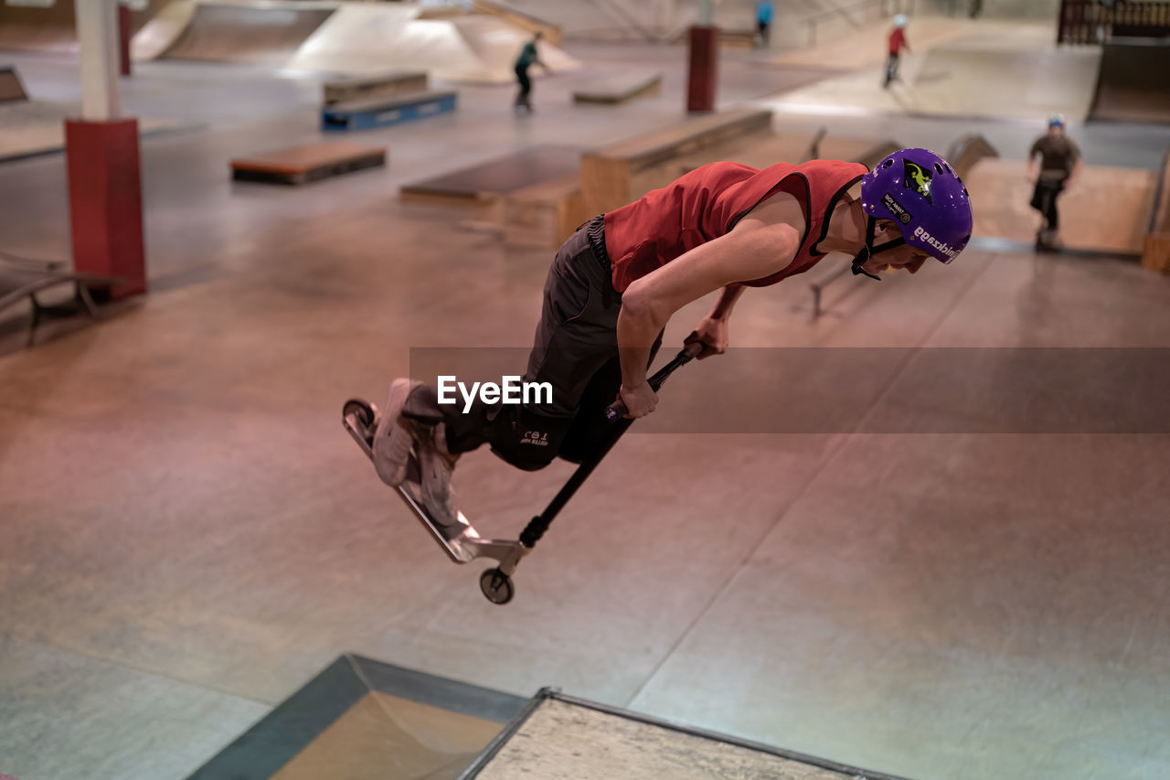 FULL LENGTH OF MAN SKATEBOARDING ON FLOOR