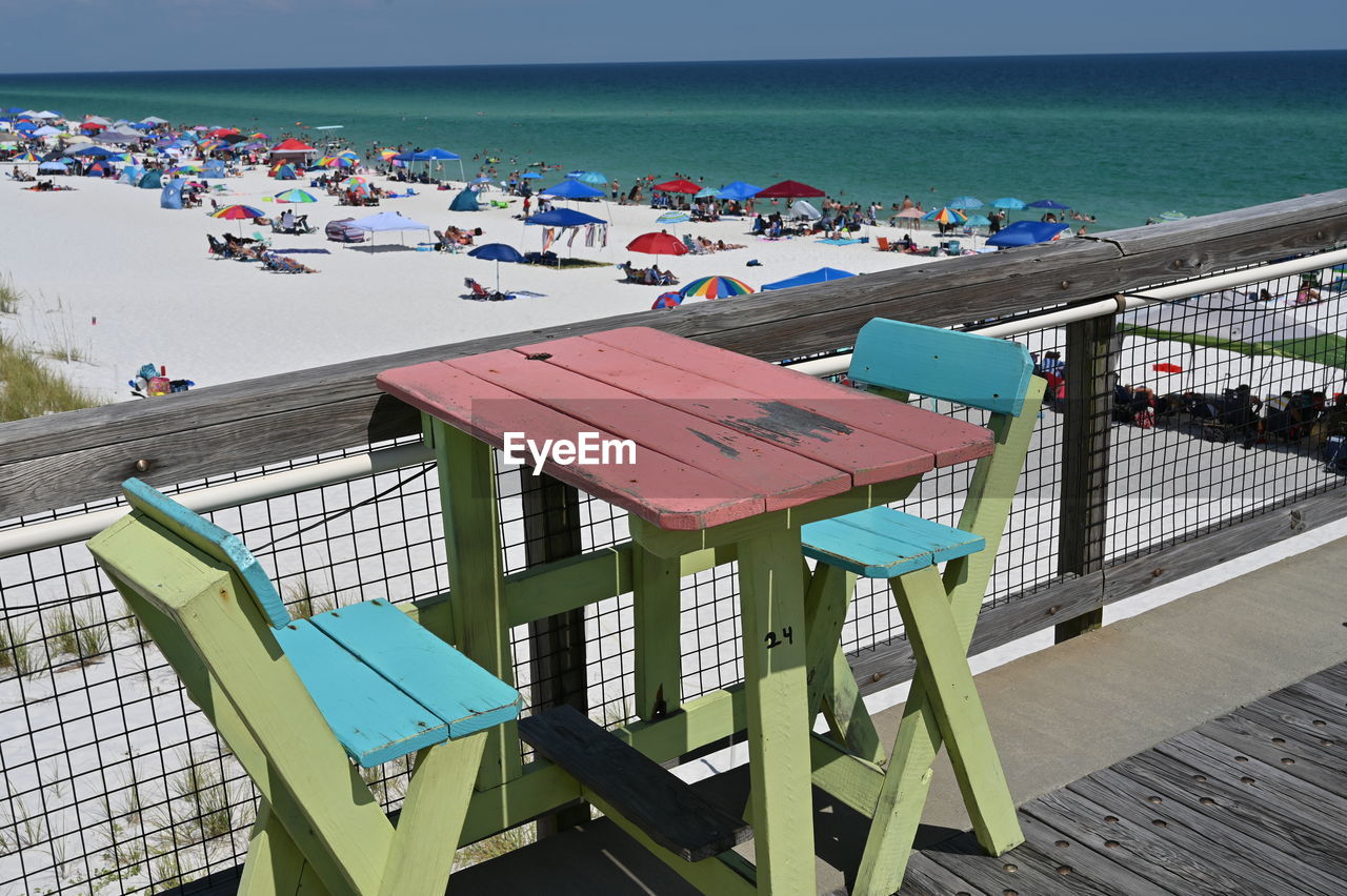 HIGH ANGLE VIEW OF CHAIRS AND TABLES ON BEACH