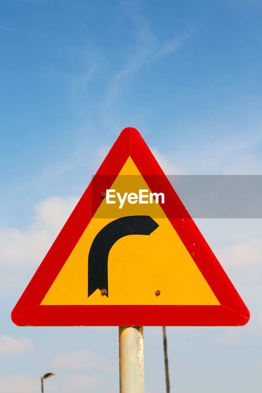 CLOSE-UP OF ROAD SIGN AGAINST SKY