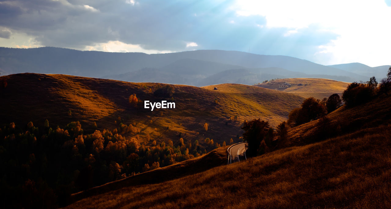 The sun at dusk through the clouds on the hills, cindrel mountains, romania