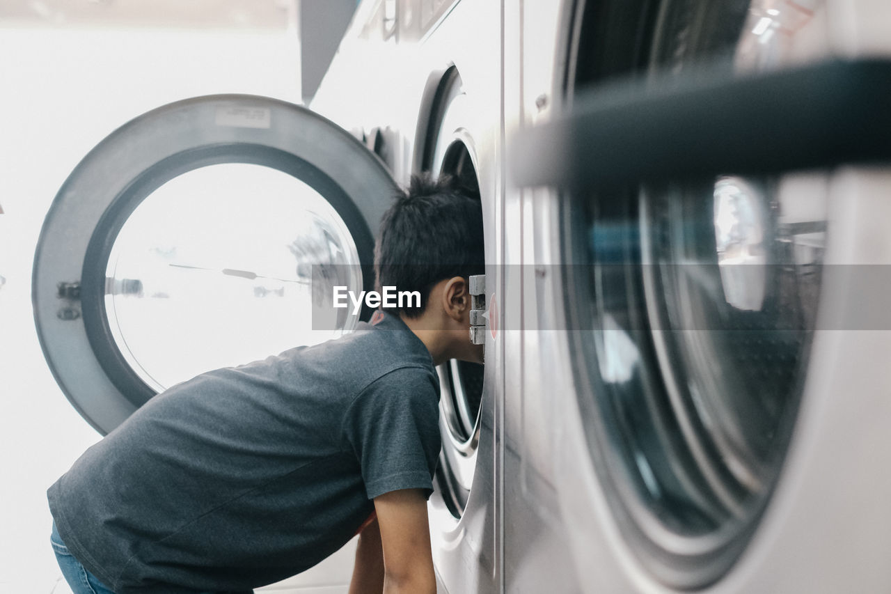 Boy looking into washing machine