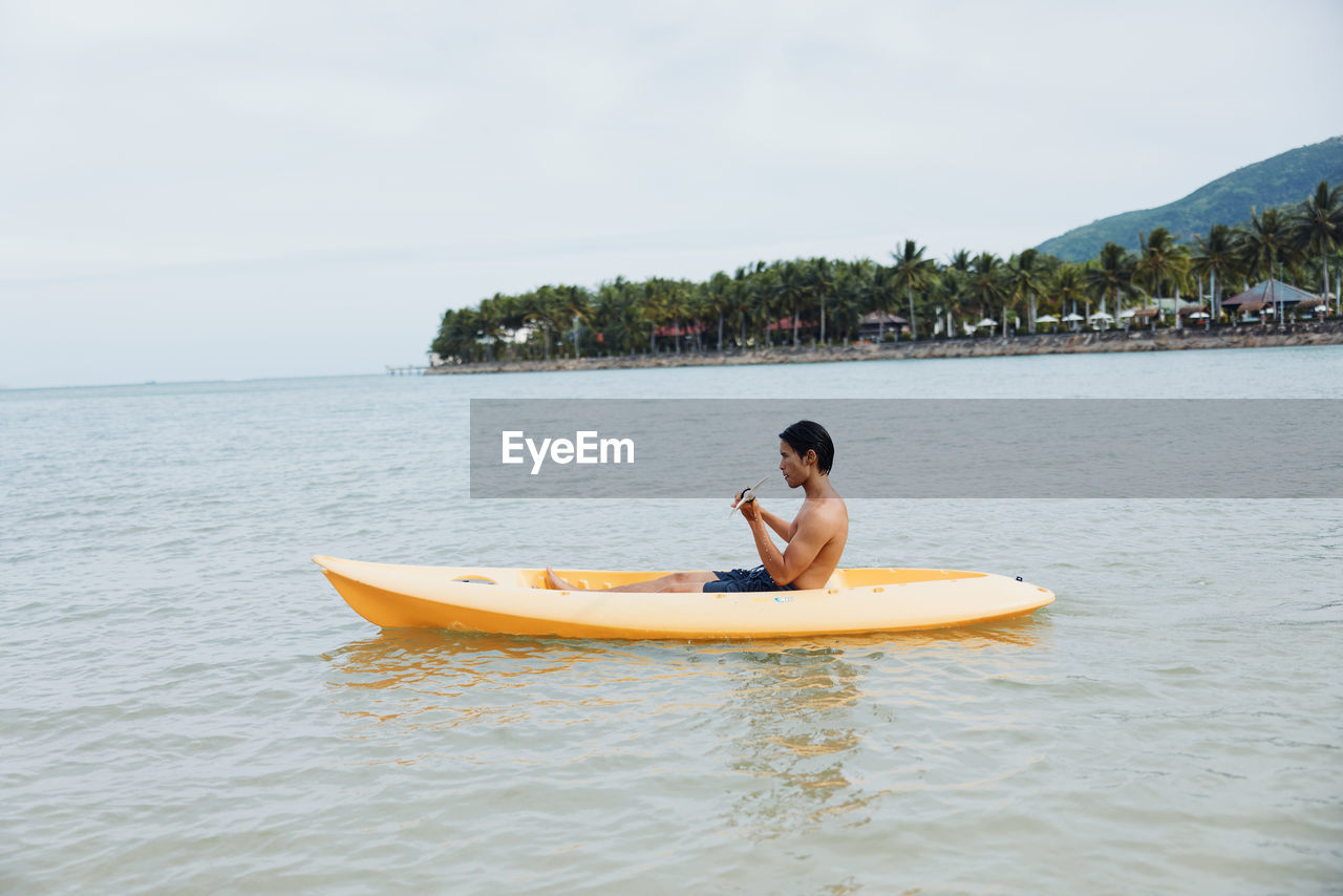 rear view of man kayaking in sea