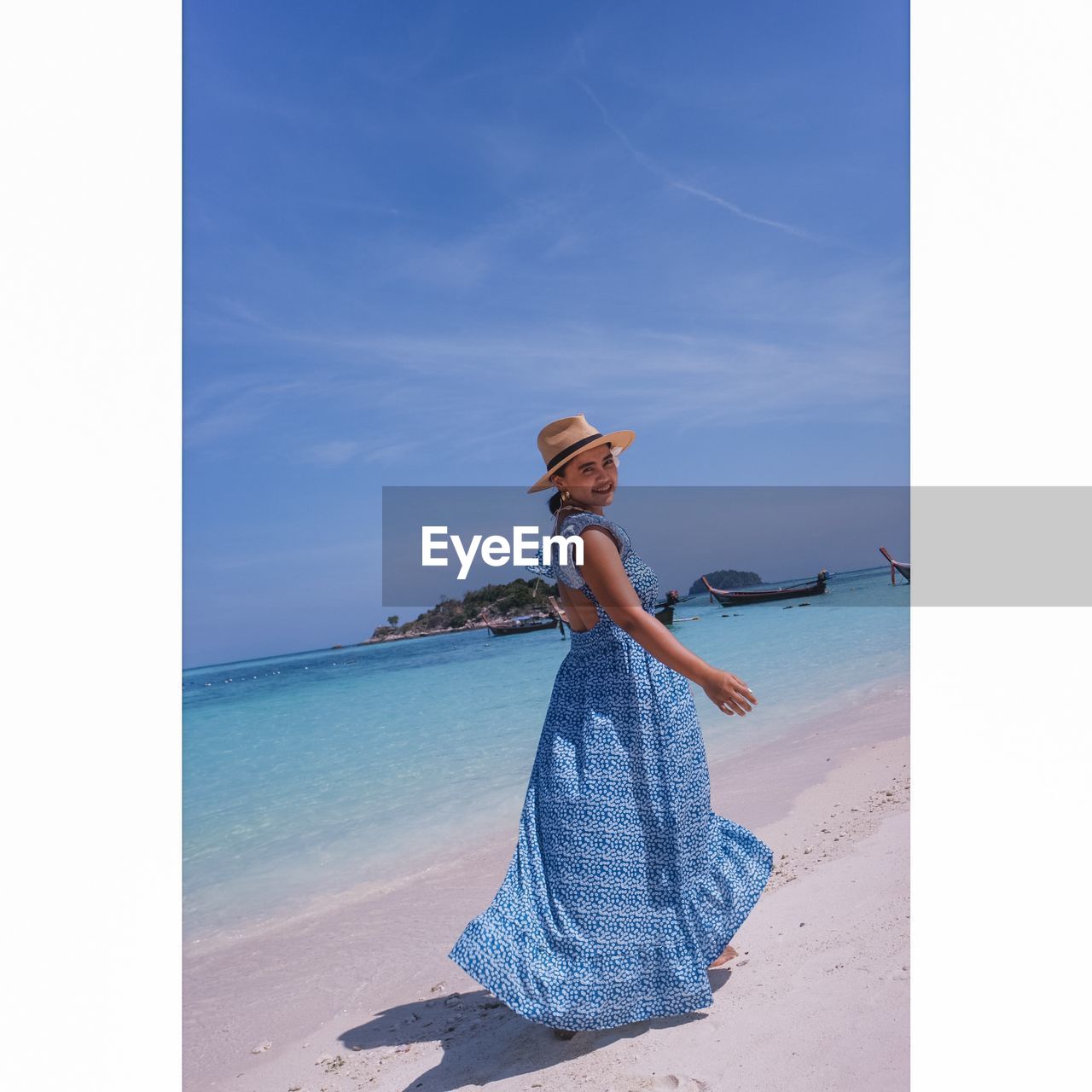 Full length portrait of woman wearing hat on beach against sky