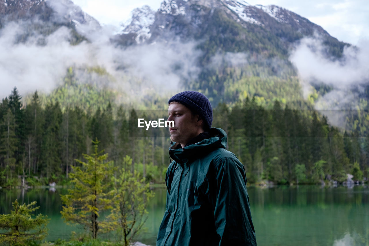 Young man looking away in forest