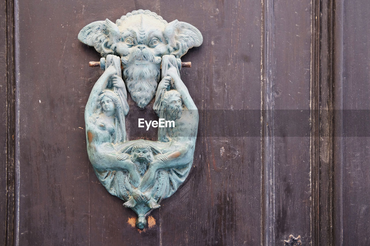 CLOSE-UP OF OLD DOOR KNOCKER ON WOODEN ENTRANCE