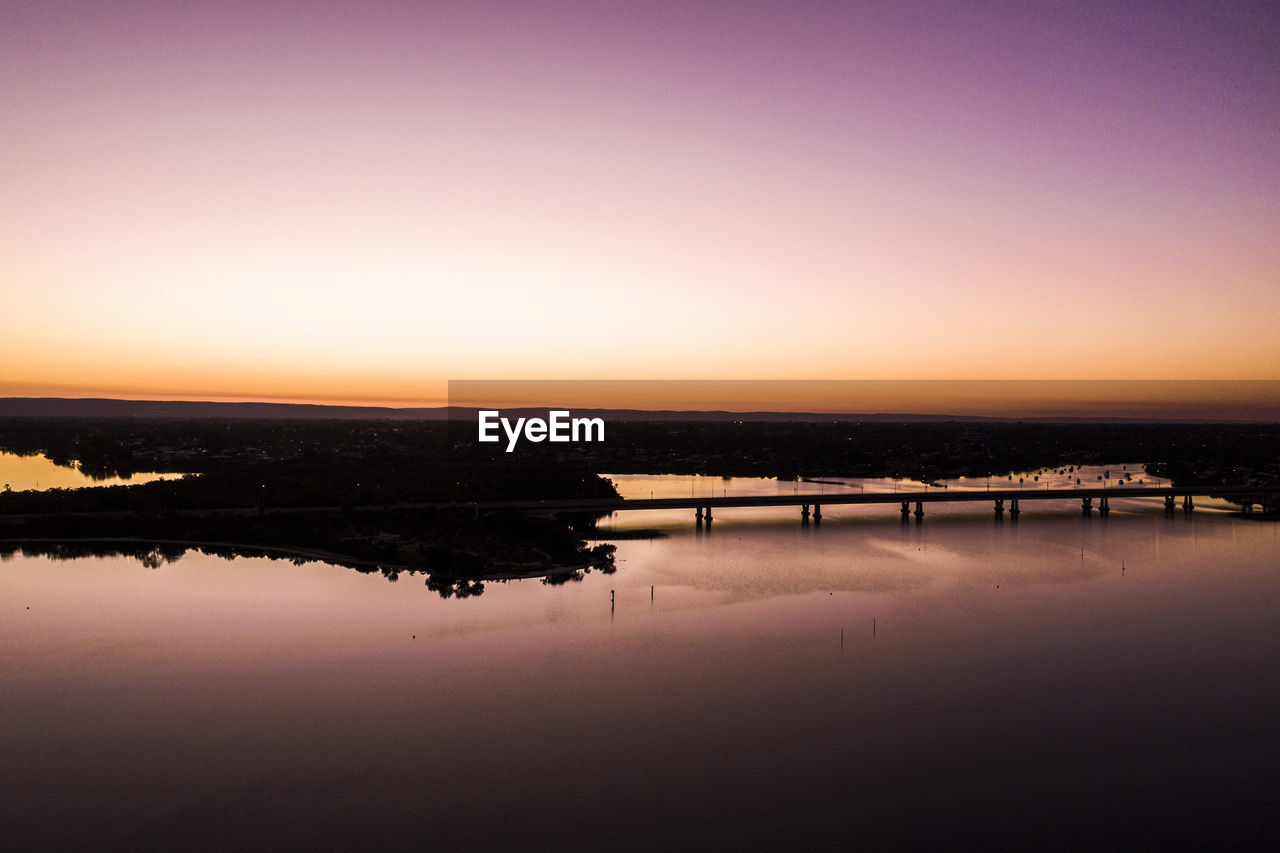 Scenic view of lake against clear sky during sunset