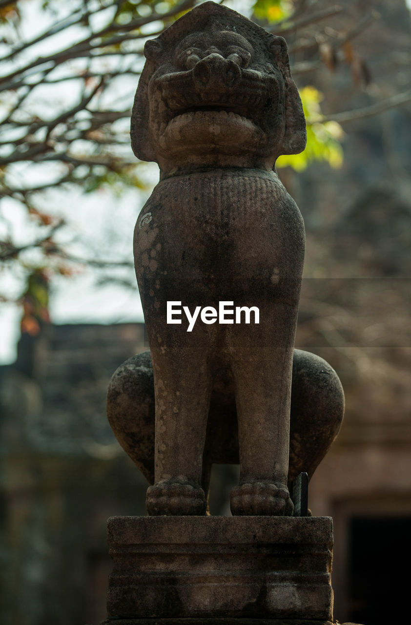 CLOSE-UP OF OLD STATUE AGAINST STONE WALL