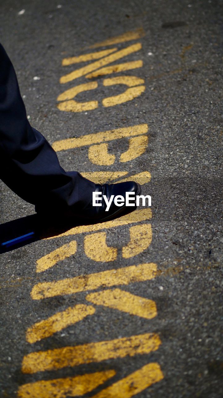 Low section of man standing on street