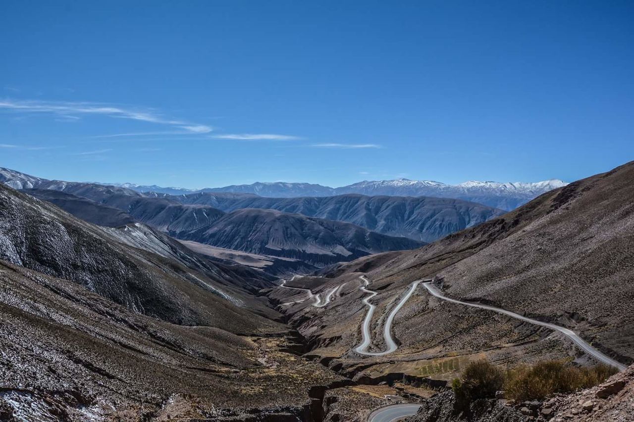 Scenic view of mountains against blue sky