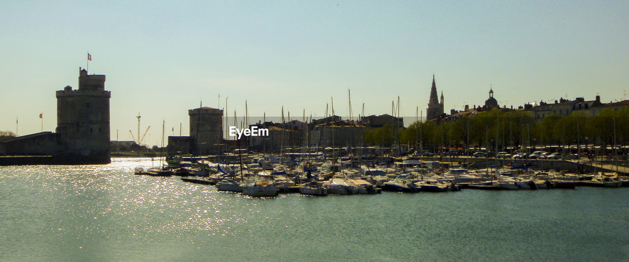 Sailboats in sea against clear sky