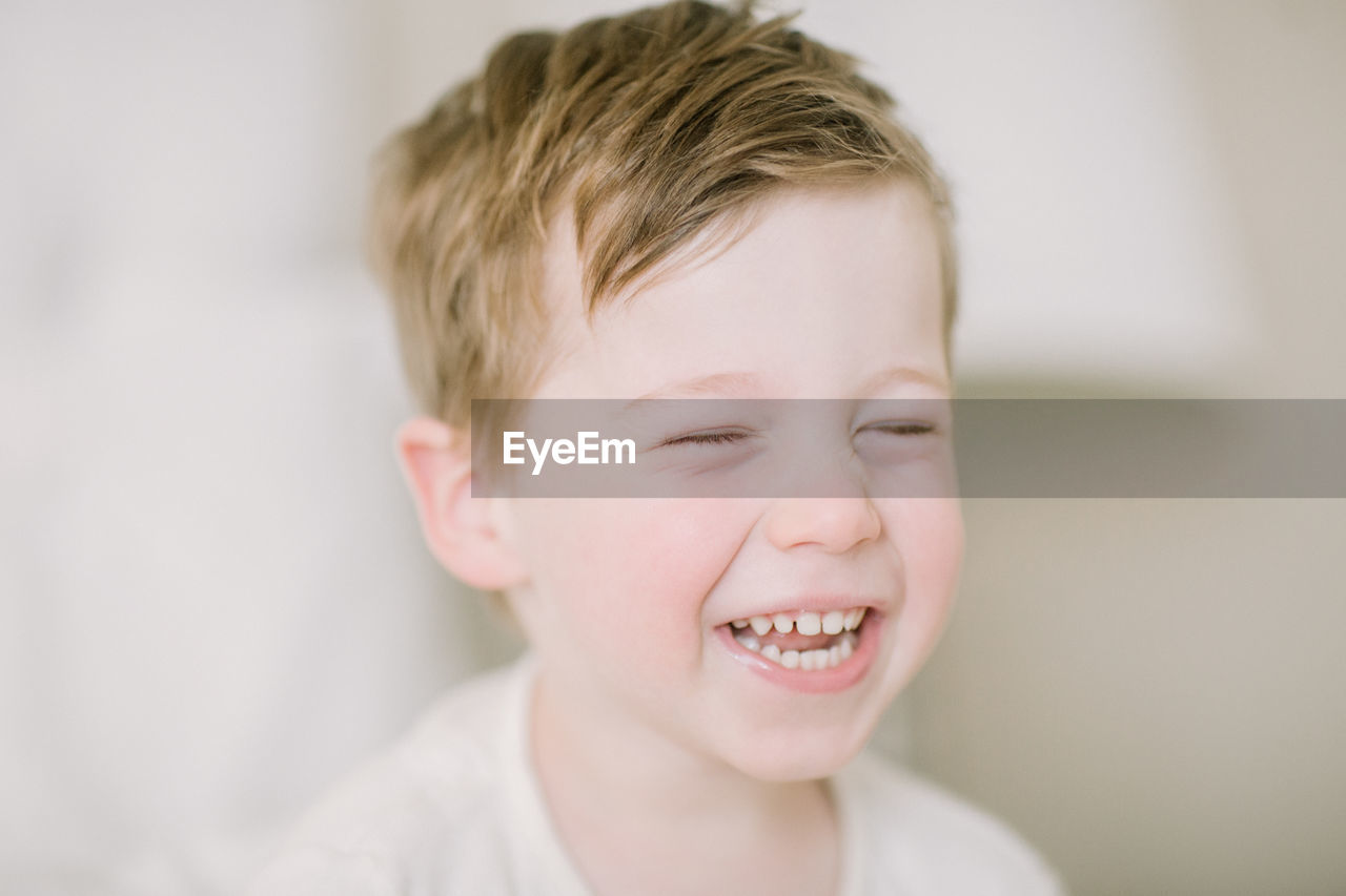 Closup of toddler boy laughing with eyes closed
