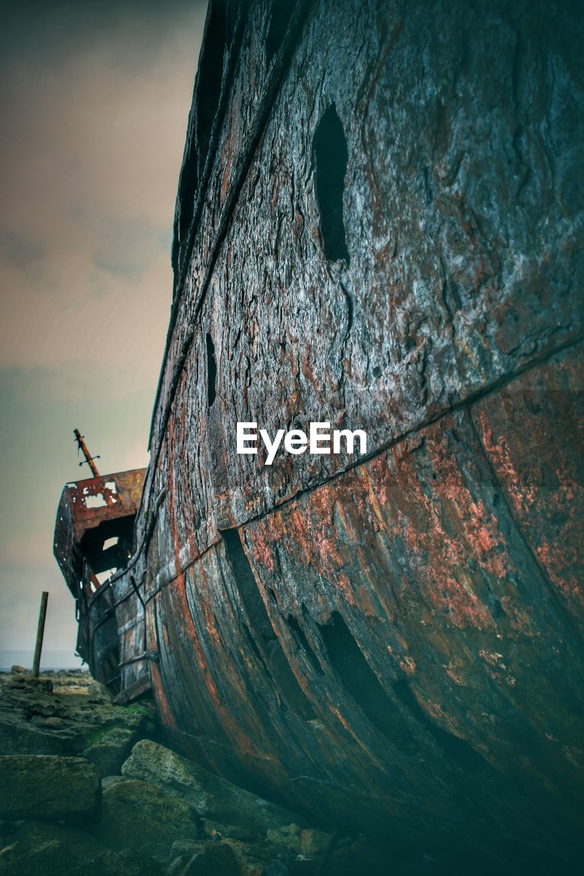 ABANDONED BOAT ON RUSTY METAL STRUCTURE