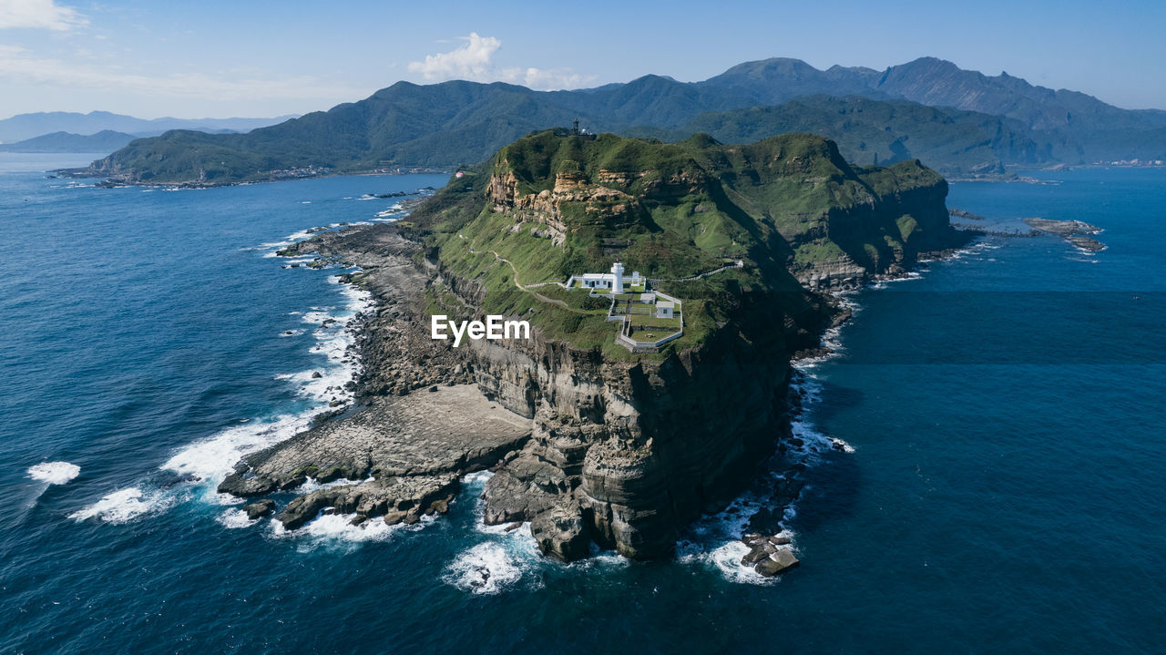 Scenic view of sea and mountains against sky