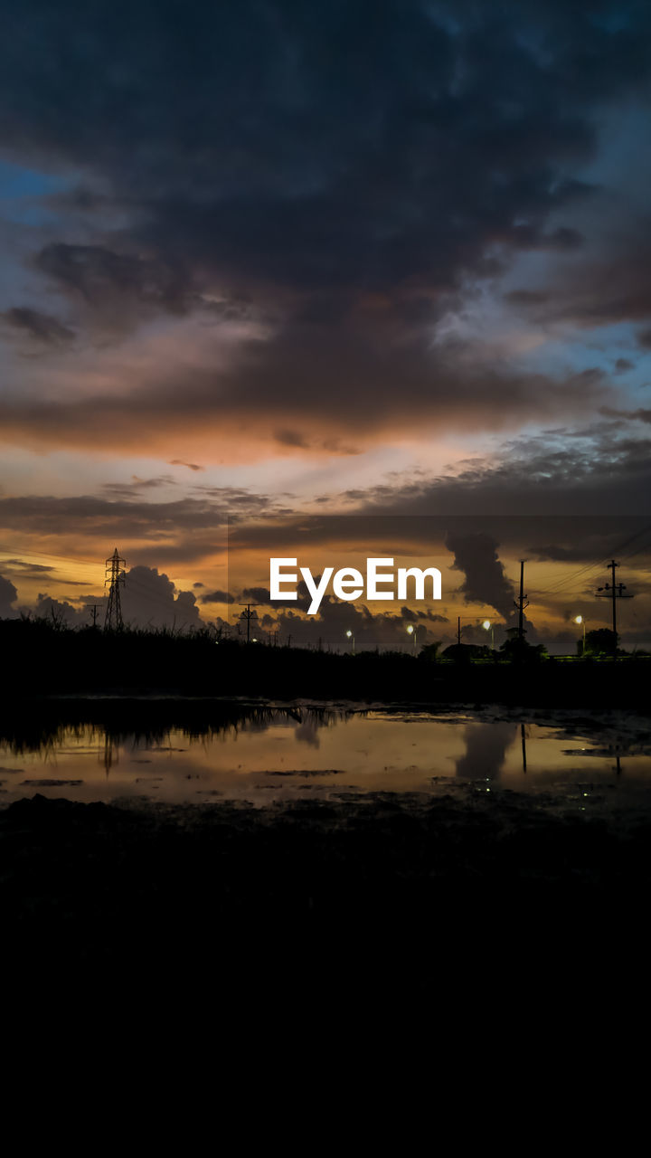 SCENIC VIEW OF LAKE AGAINST SKY AT SUNSET