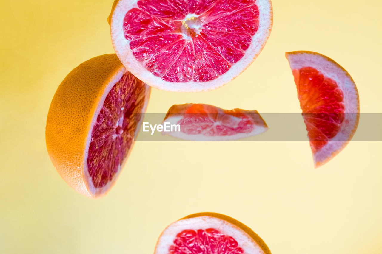 CLOSE-UP OF FRUITS WITH PINK SLICES OVER WHITE BACKGROUND