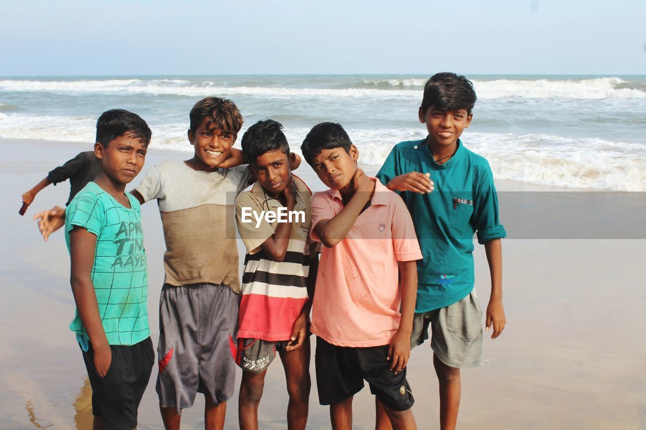 REAR VIEW OF BOYS ON BEACH