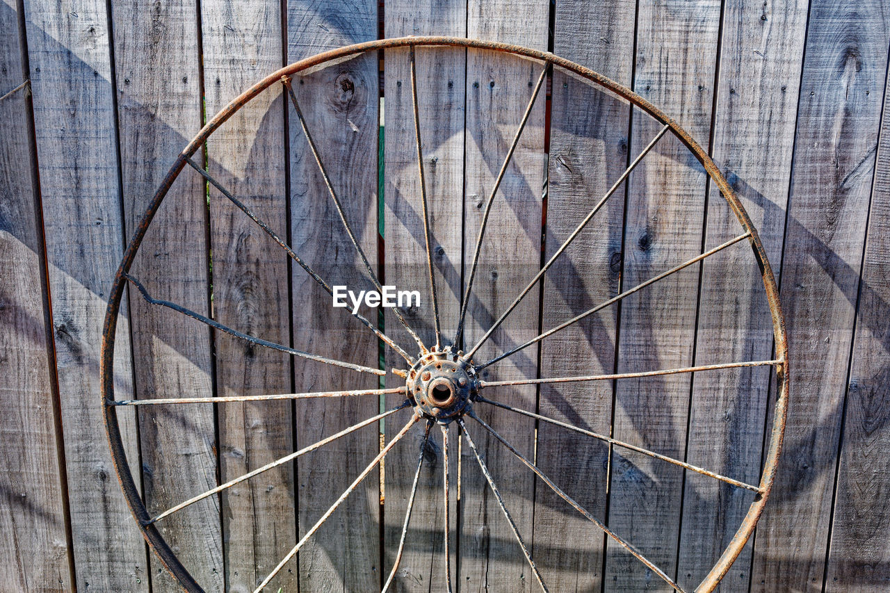 wheel, no people, spoke, bicycle wheel, wood, circle, pattern, geometric shape, bicycle, shape, metal, day, backgrounds, architecture, close-up, transportation, full frame, built structure, iron, outdoors, line, wall - building feature