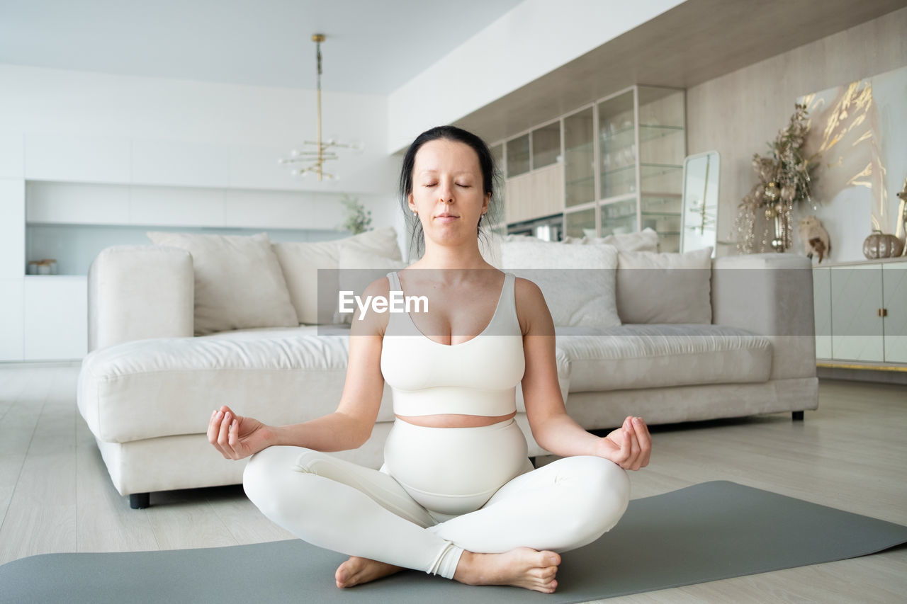 Pregnant woman meditating at home