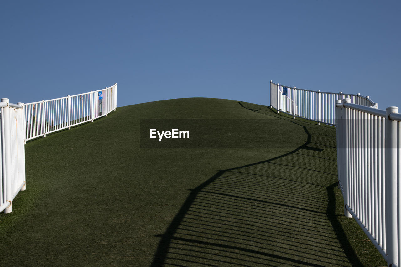 Low angle view of hill against clear blue sky