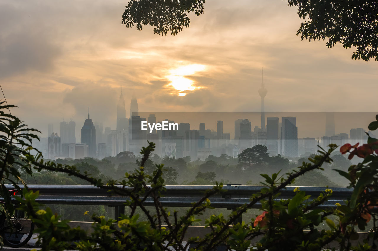 Buildings in city against cloudy sky