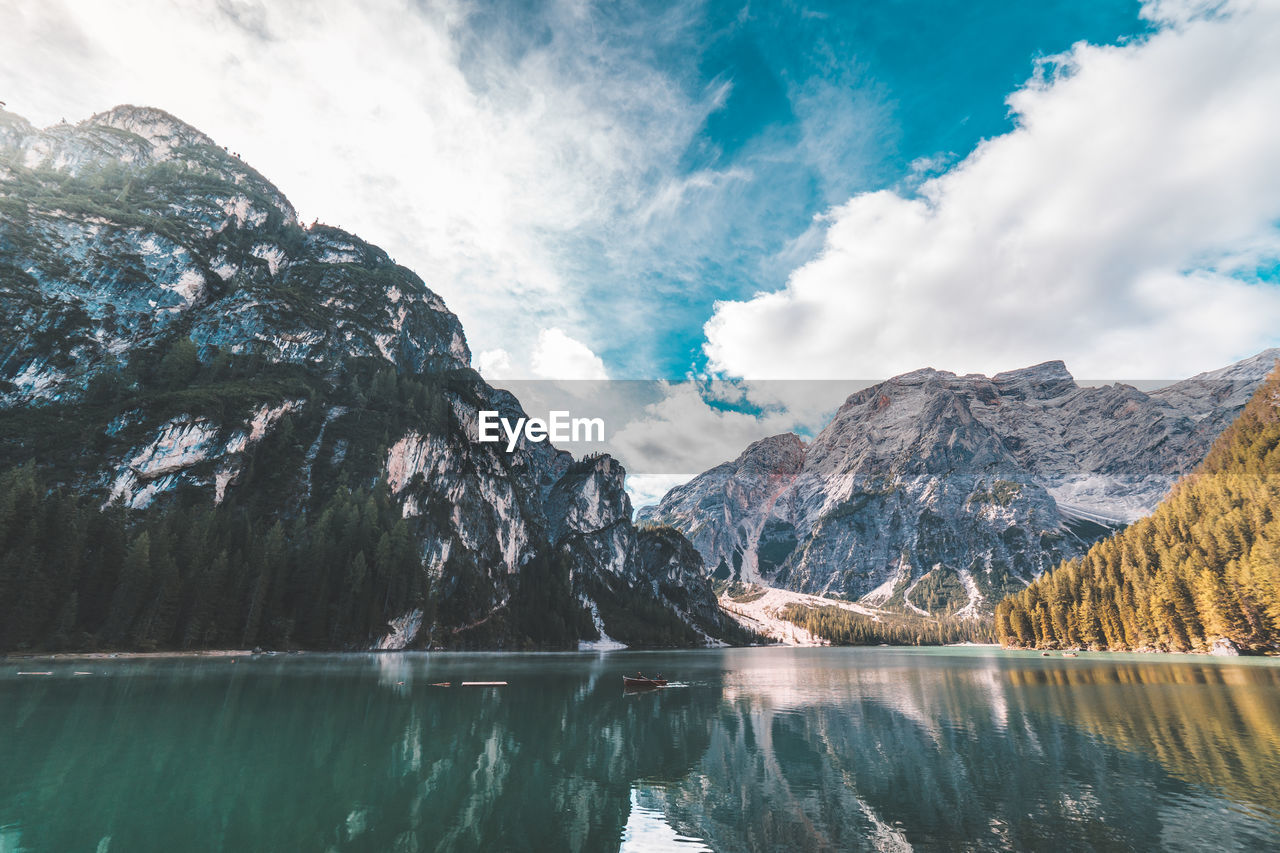 Scenic view of lake and mountains against cloudy sky