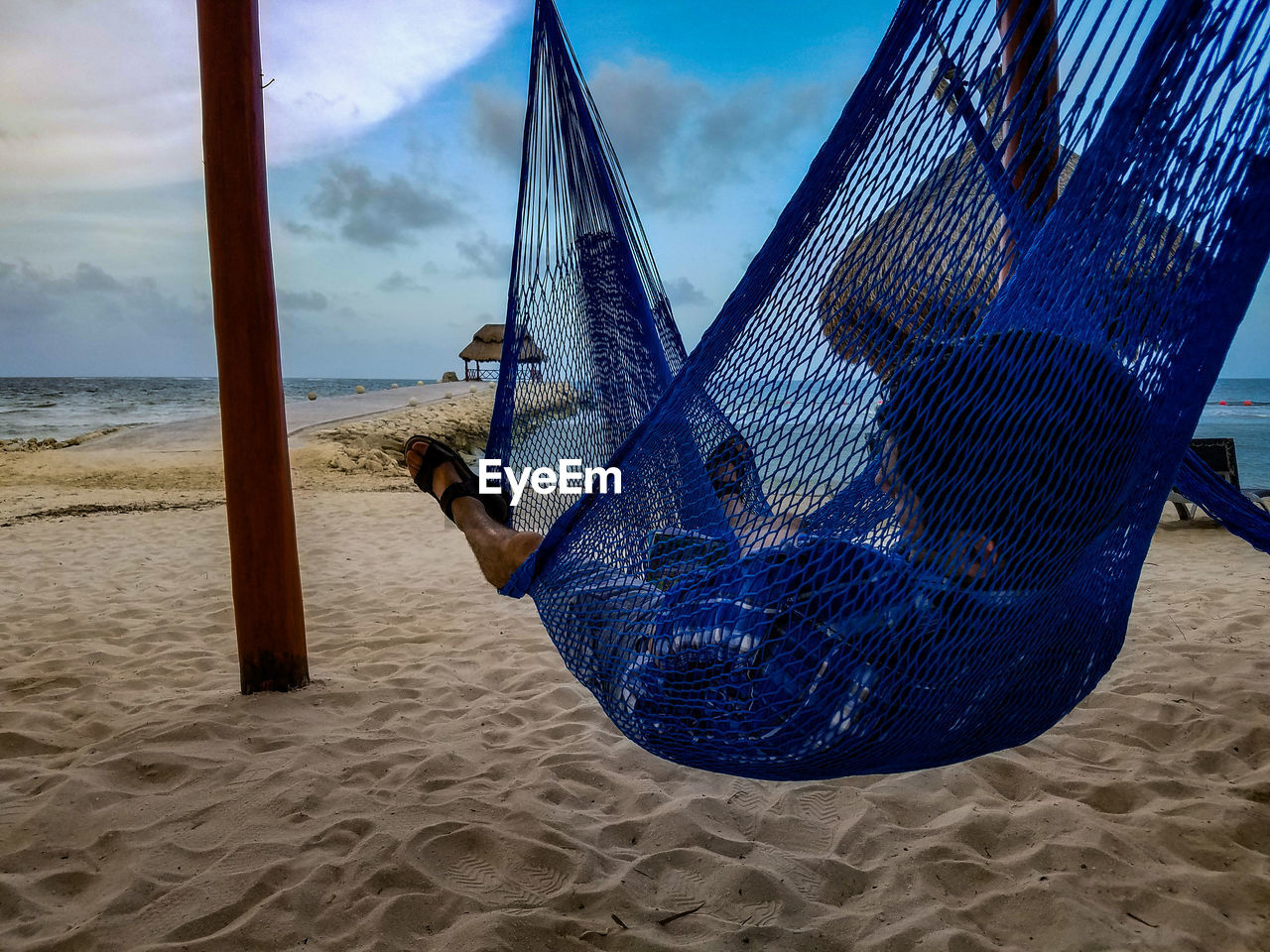 Man resting in hammock on beach