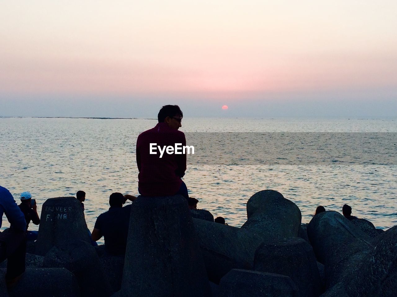 REAR VIEW OF A COUPLE ON BEACH AT SUNSET