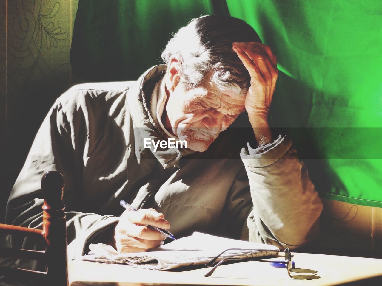 Close-up of senior man with pen and paper on desk at home