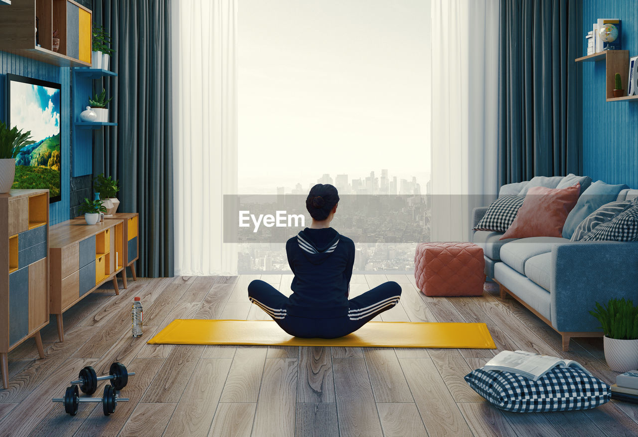 MAN SITTING ON WOODEN FLOOR AT HOME