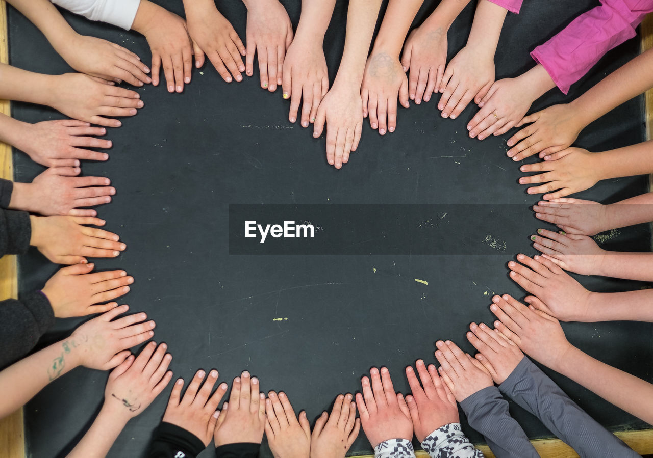 High angle view of people making heart shape from hands