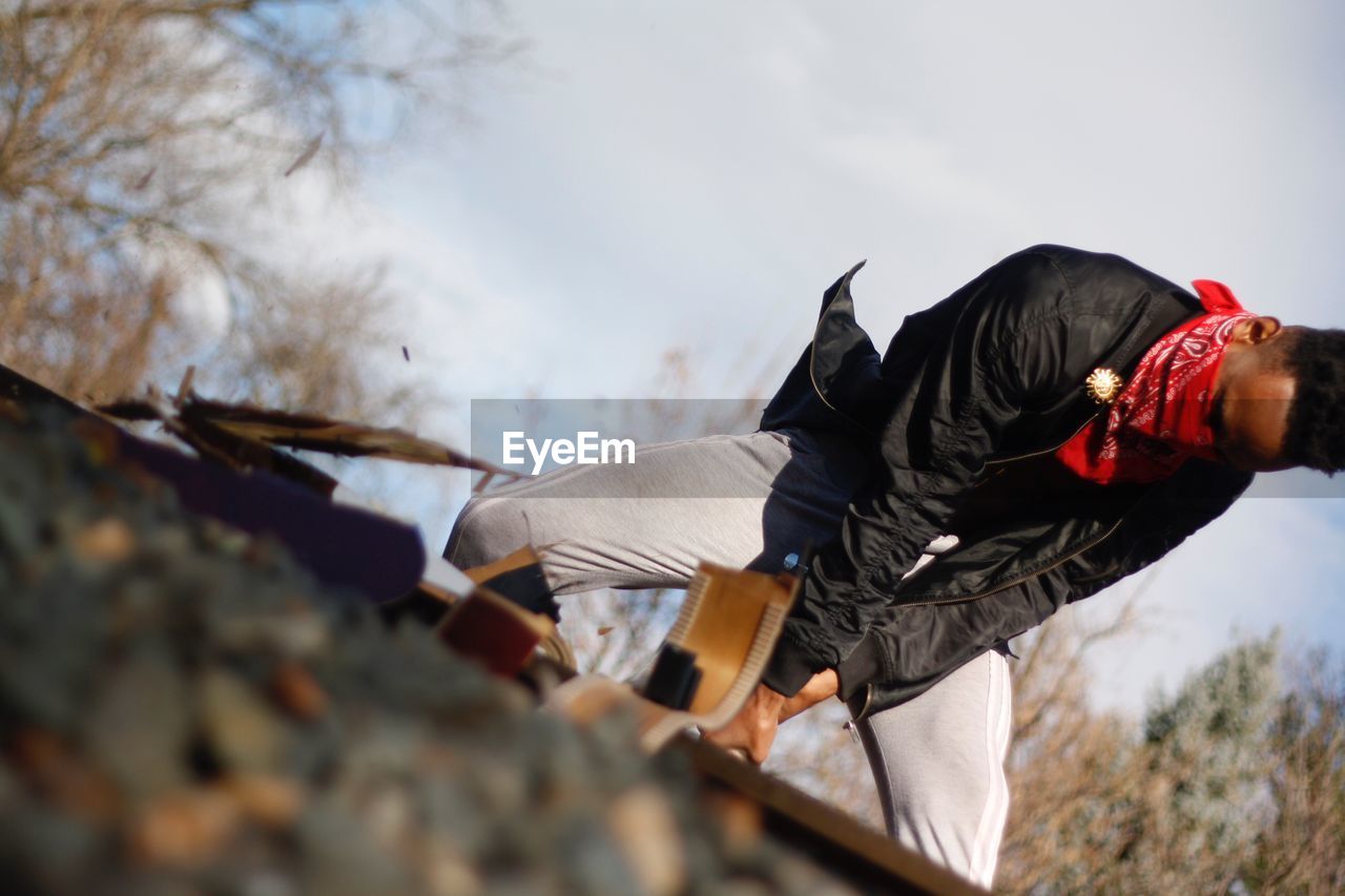 Tilt shot of man on railroad tracks against sky