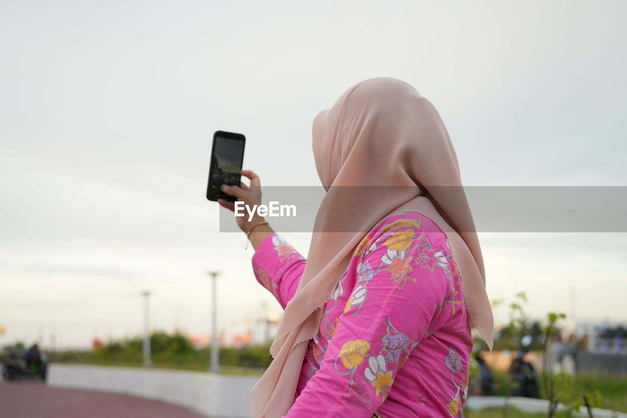 midsection of woman using mobile phone