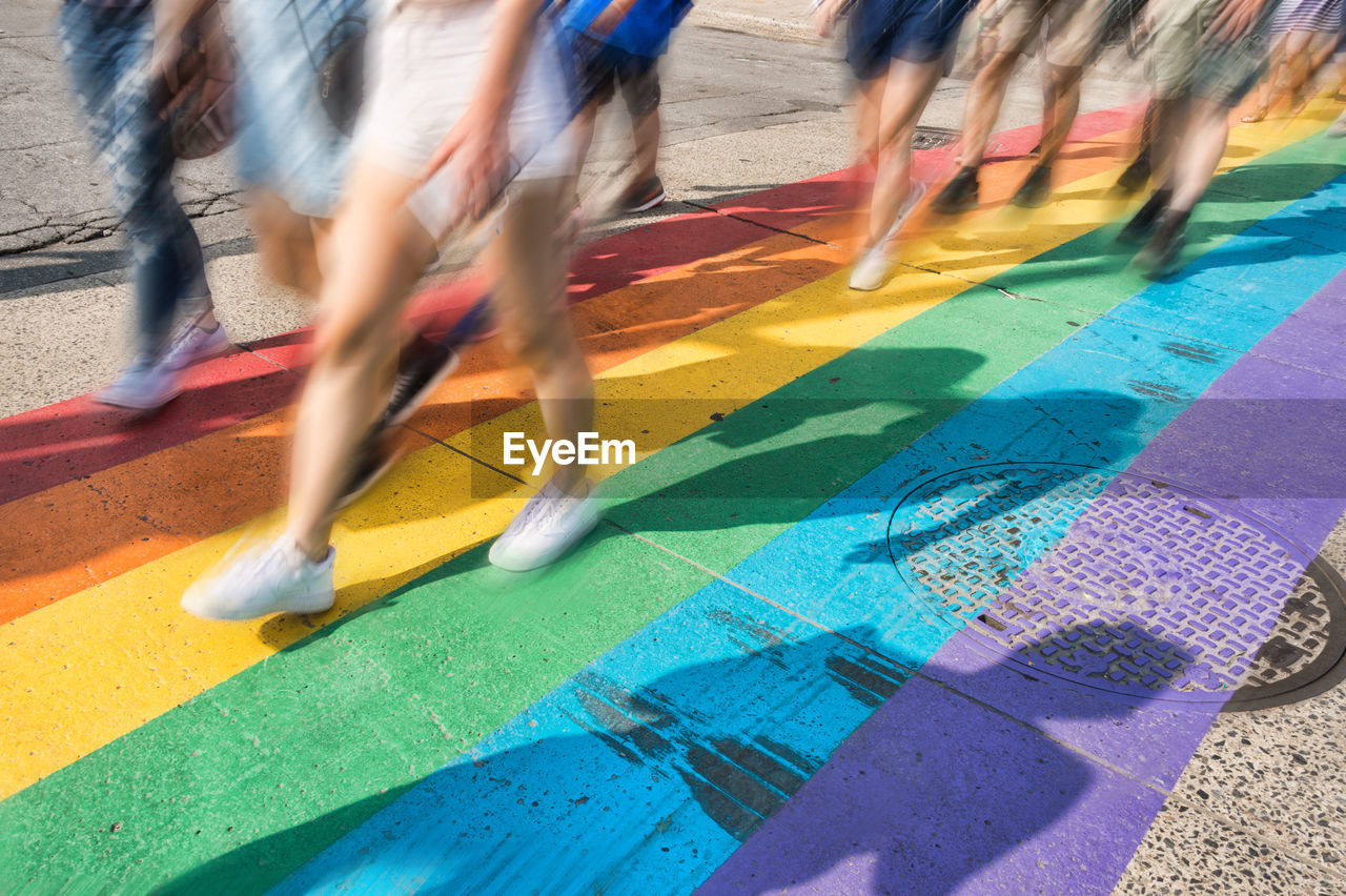 Blurred motion of people walking on colorful street during parade