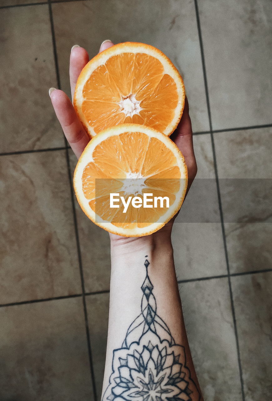 Cropped hand holding oranges