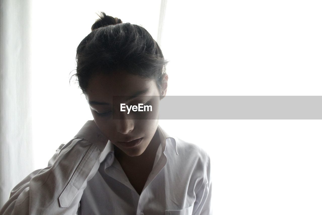 Close-up of teenage girl at window