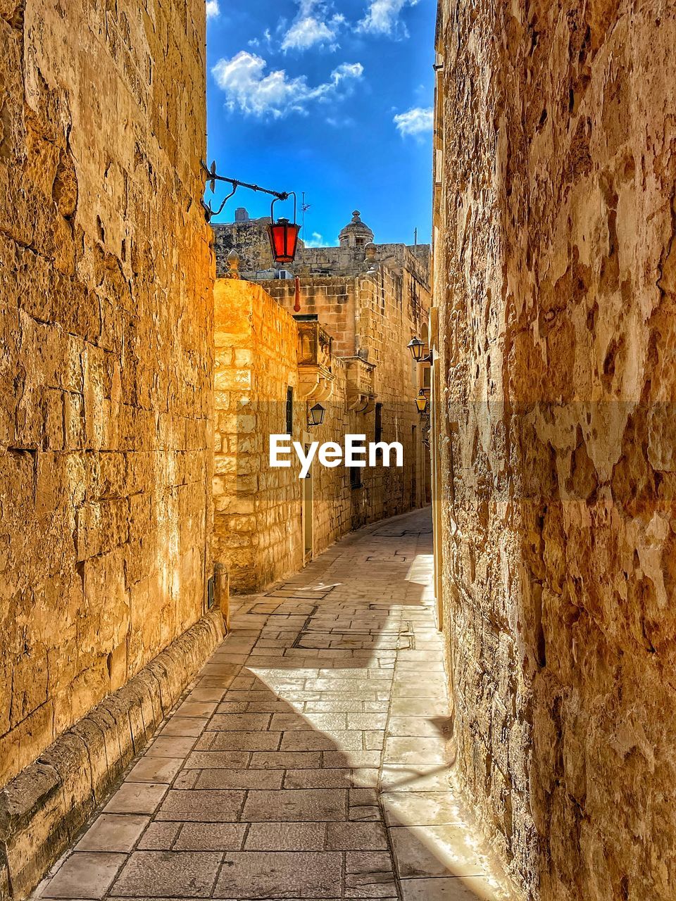 Narrow alley amidst buildings against sky
