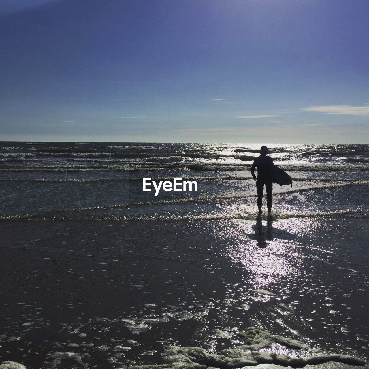 SILHOUETTE PERSON STANDING ON BEACH AGAINST SKY