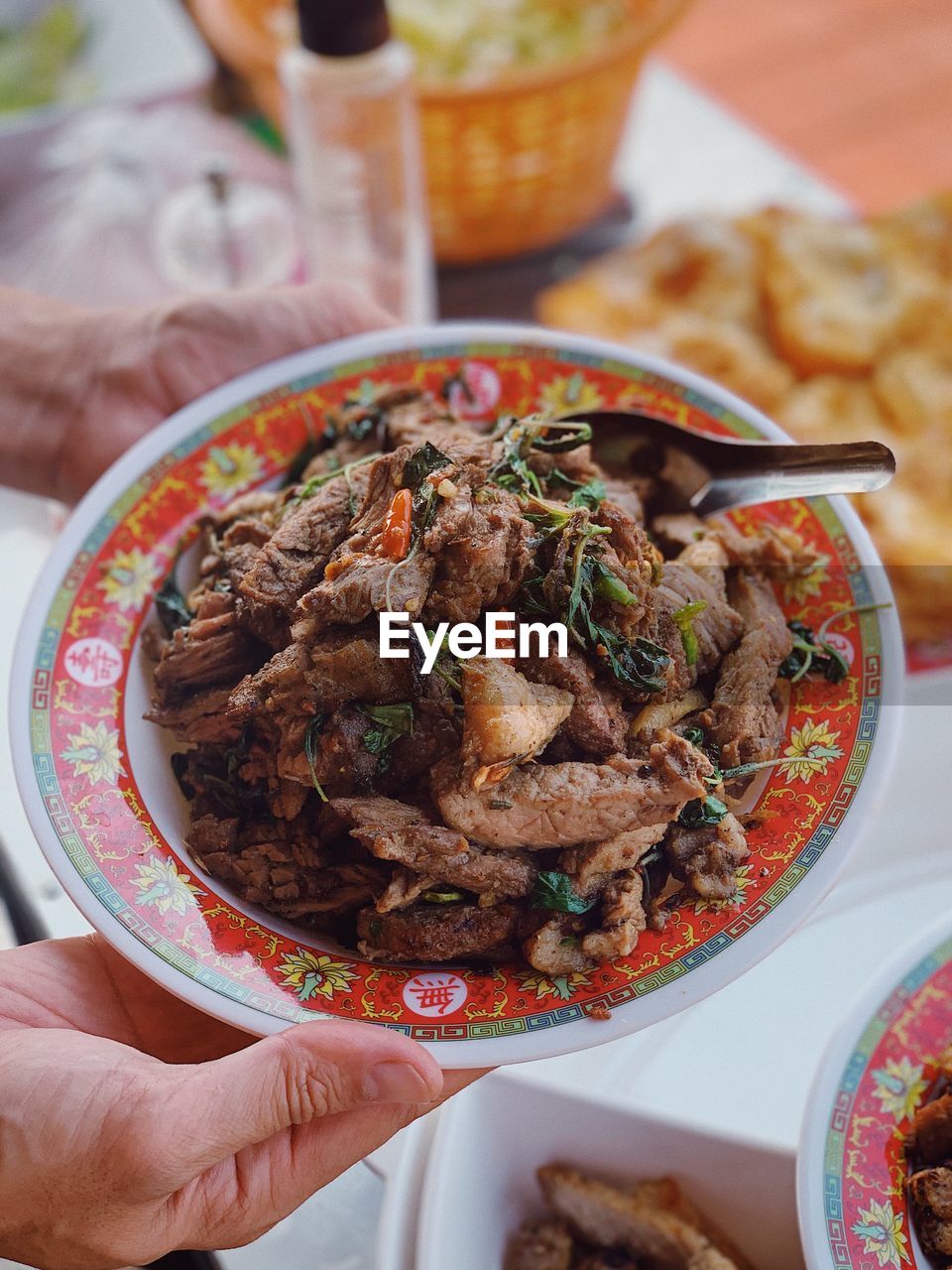 CLOSE-UP OF HAND HOLDING FOOD SERVED IN BOWL