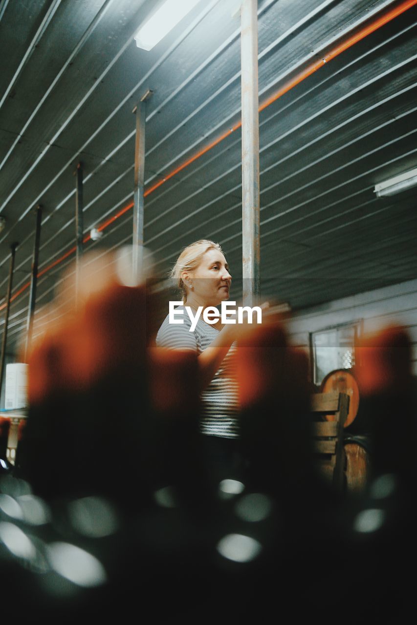 Woman looking away while standing in restaurant