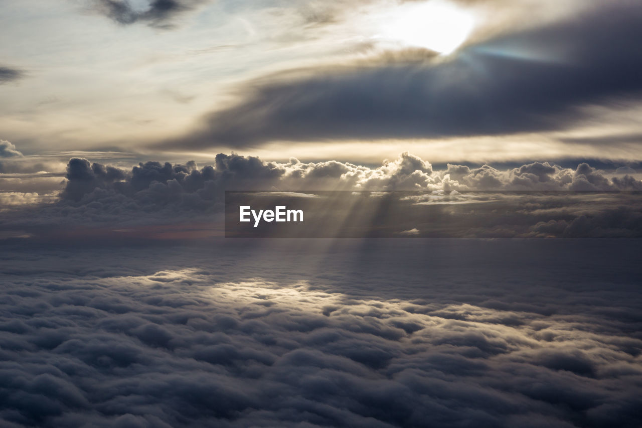 Sun shining through clouds seen from the sky