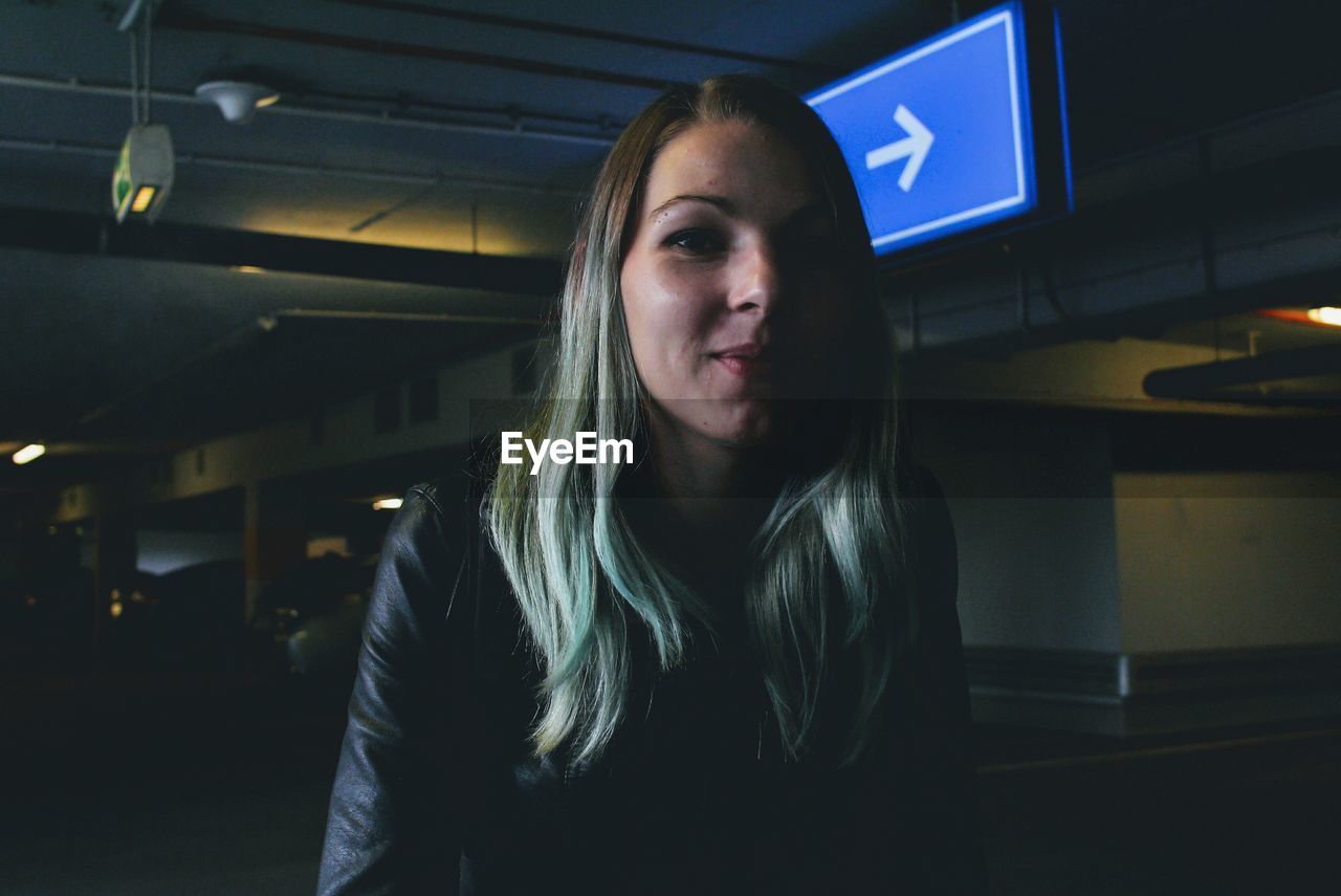 Portrait of young woman smiling at parking garage