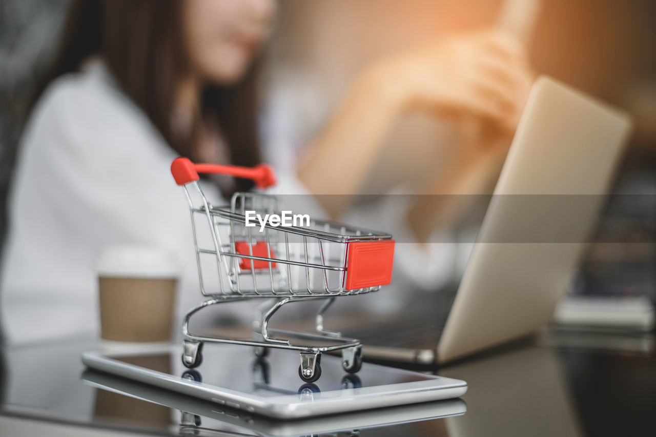 MIDSECTION OF WOMAN USING LAPTOP IN STORE