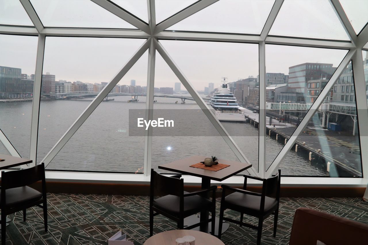 View of cityscape against sky seen through glass window
